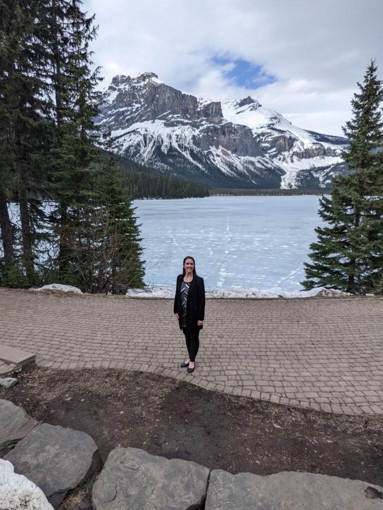 Aimee standing in front of a lake and mountains