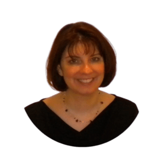 A woman with short brown hair and a black top smiles at the camera against a plain background.